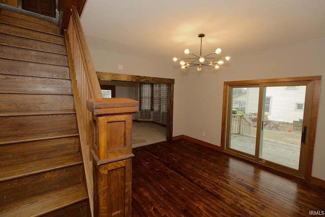 interior space with dark wood-type flooring, a chandelier, stairway, and baseboards