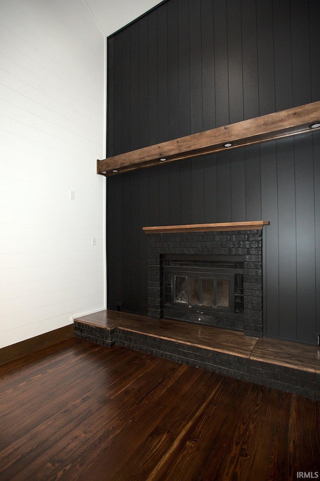 interior details featuring a fireplace, baseboards, and wood finished floors