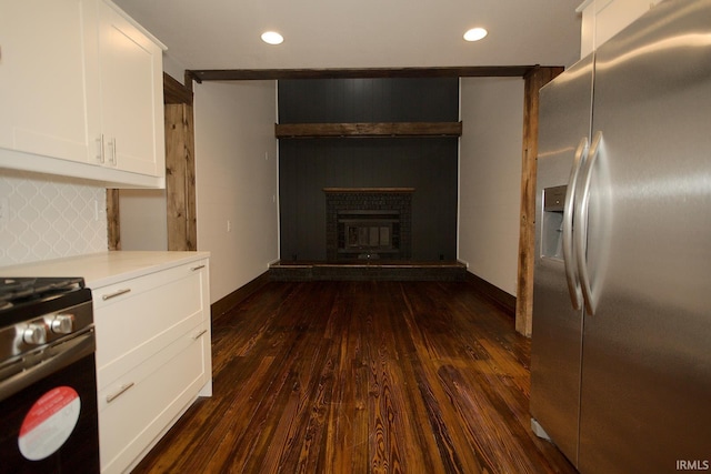 kitchen featuring tasteful backsplash, light countertops, appliances with stainless steel finishes, dark wood-type flooring, and white cabinetry