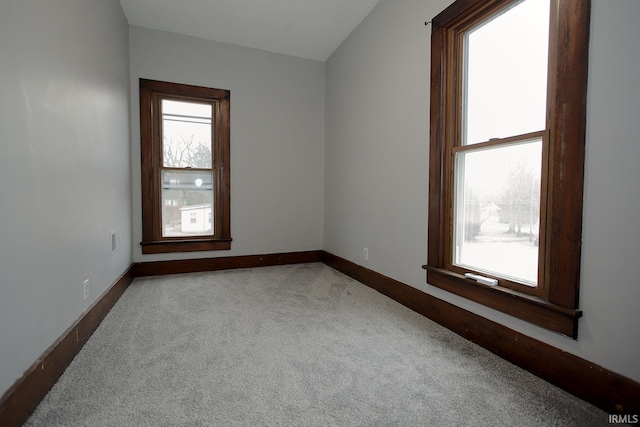 carpeted spare room with baseboards