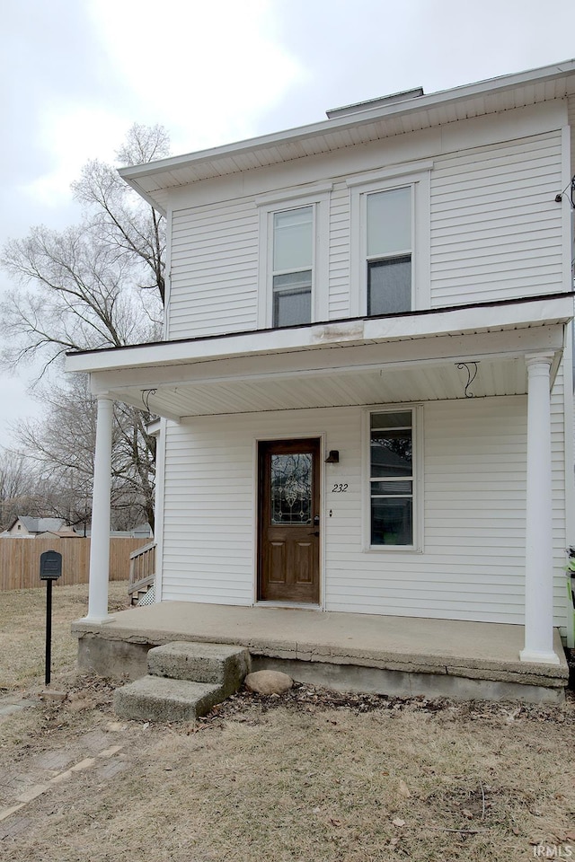 view of front of property with covered porch and fence