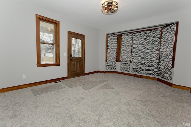 carpeted entryway featuring visible vents and baseboards