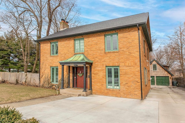 colonial-style house with a front yard, a chimney, fence, and brick siding