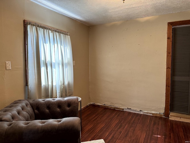 unfurnished room with dark wood-style floors and a textured ceiling