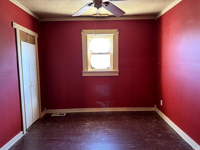 spare room with baseboards, visible vents, ceiling fan, hardwood / wood-style floors, and a textured ceiling