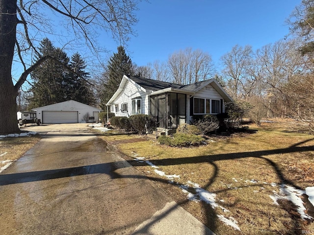 view of front of property with a garage, an outdoor structure, and a front yard