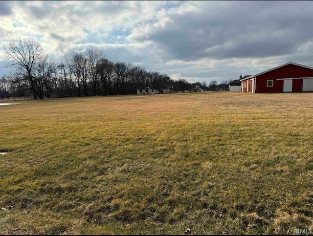 view of yard featuring an outbuilding, a pole building, and a detached garage