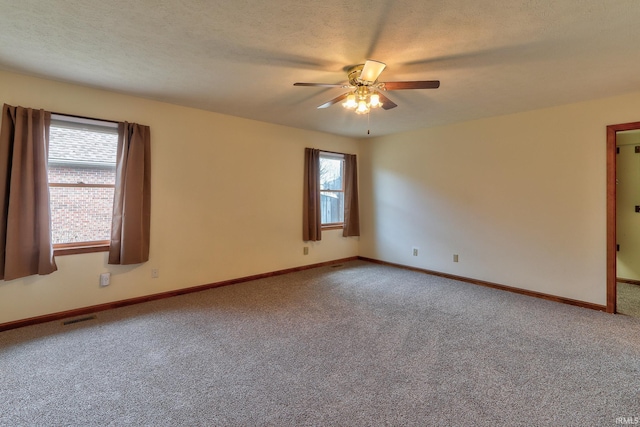 unfurnished room featuring a textured ceiling, carpet flooring, visible vents, and a ceiling fan