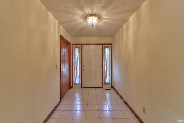 entrance foyer with visible vents, a textured ceiling, baseboards, and light tile patterned floors