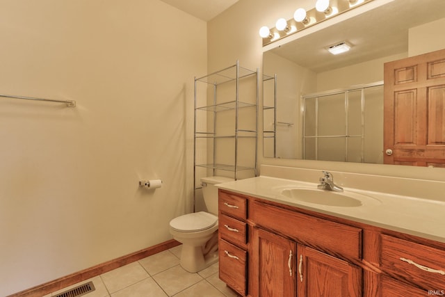 bathroom featuring baseboards, toilet, tile patterned flooring, vanity, and a shower stall