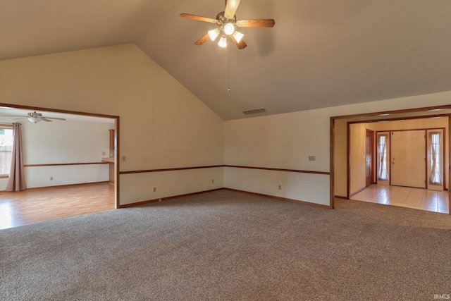 spare room with high vaulted ceiling, light colored carpet, visible vents, baseboards, and a ceiling fan