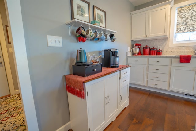 kitchen featuring tasteful backsplash, visible vents, dark wood finished floors, light countertops, and white cabinetry