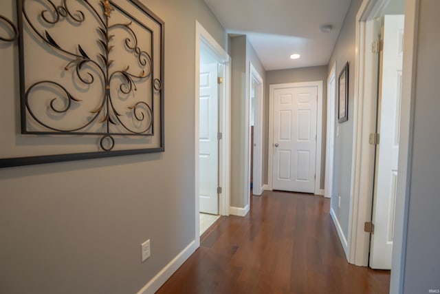 hall featuring baseboards, dark wood-style flooring, and recessed lighting