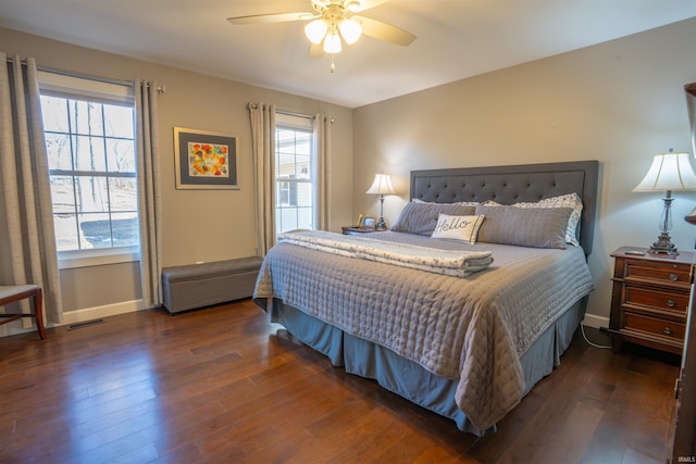 bedroom featuring a ceiling fan, baseboards, visible vents, and wood finished floors