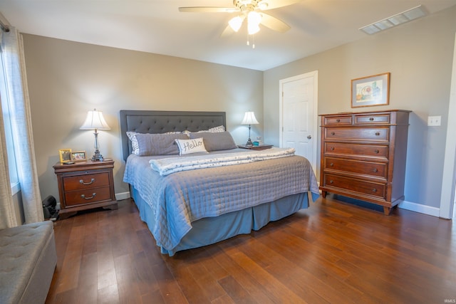 bedroom with ceiling fan, dark wood-style flooring, visible vents, and baseboards