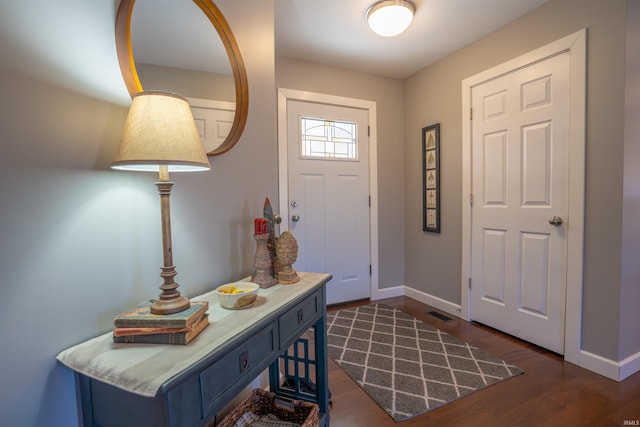 foyer featuring baseboards and dark wood finished floors