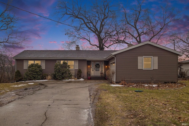 ranch-style home with driveway, a garage, and a front yard