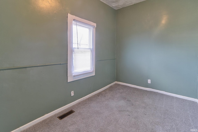 carpeted spare room with baseboards and visible vents