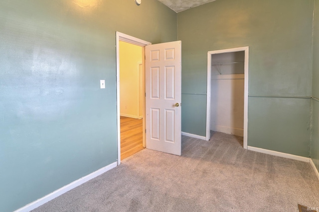 unfurnished bedroom featuring a closet, carpet, and baseboards