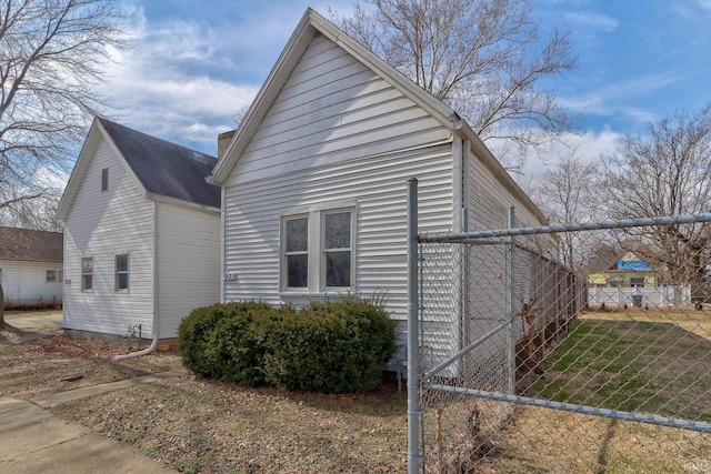 view of side of home featuring a chimney and fence