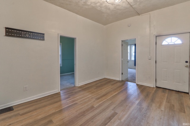 entryway with wood finished floors, visible vents, and baseboards