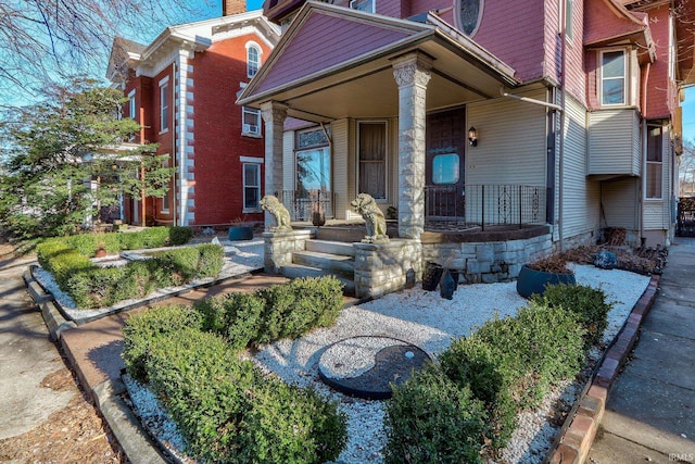 property entrance featuring covered porch and a chimney