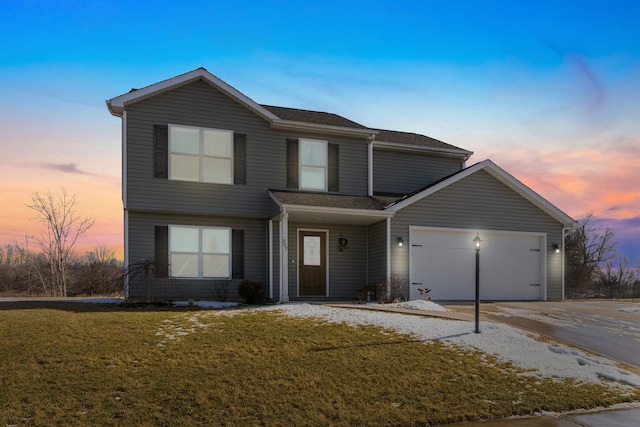 traditional-style home with an attached garage, driveway, and a lawn