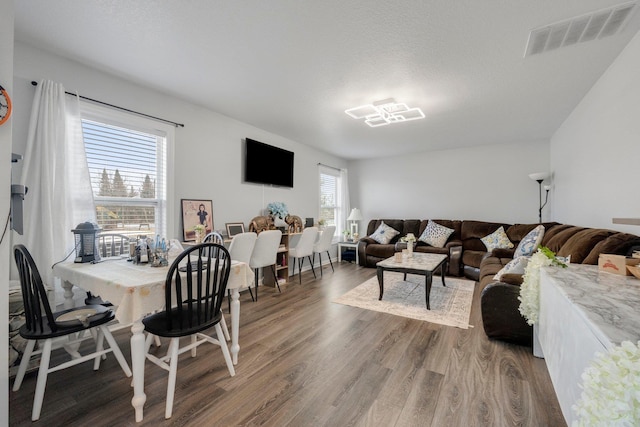 living area featuring visible vents, a textured ceiling, and wood finished floors