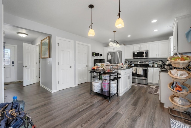 kitchen with recessed lighting, dark wood-type flooring, white cabinetry, appliances with stainless steel finishes, and dark countertops