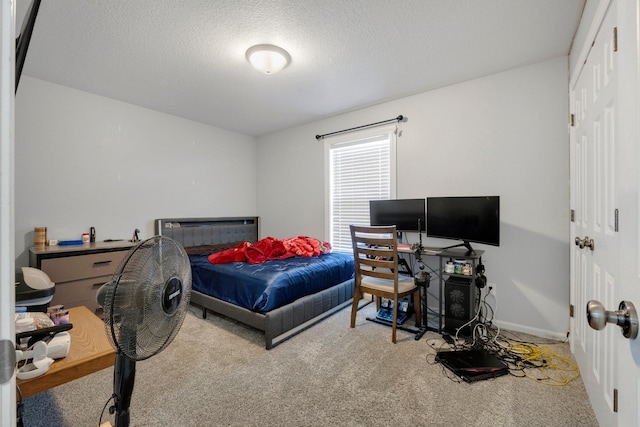 carpeted bedroom featuring a closet, a textured ceiling, and baseboards