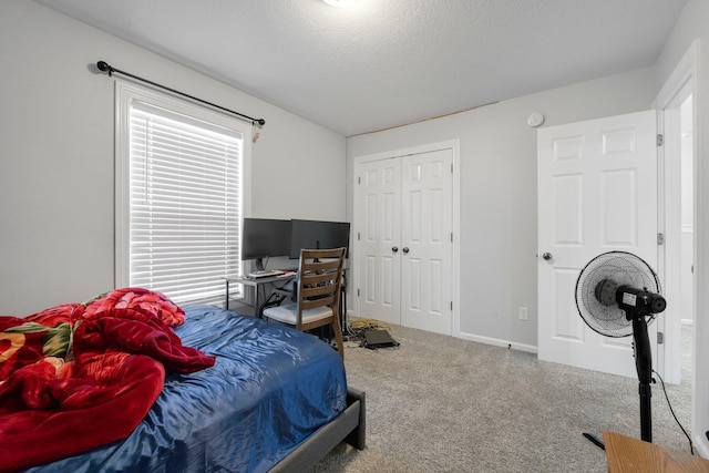 bedroom with carpet floors, a closet, a textured ceiling, and baseboards