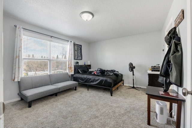 bedroom featuring a textured ceiling, carpet flooring, and baseboards