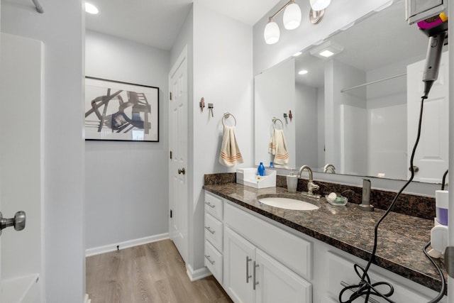 full bathroom with a shower, vanity, baseboards, and wood finished floors