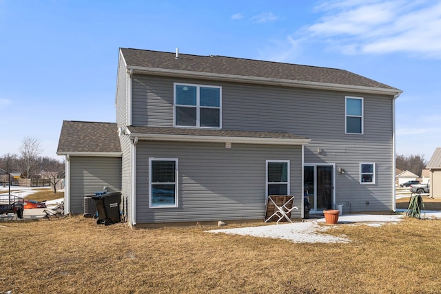 rear view of house with a shingled roof, a yard, and a patio