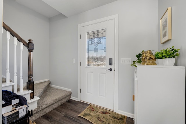 foyer with stairs, wood finished floors, and baseboards