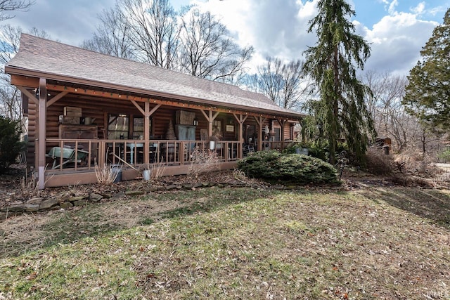 rear view of property featuring covered porch and roof with shingles