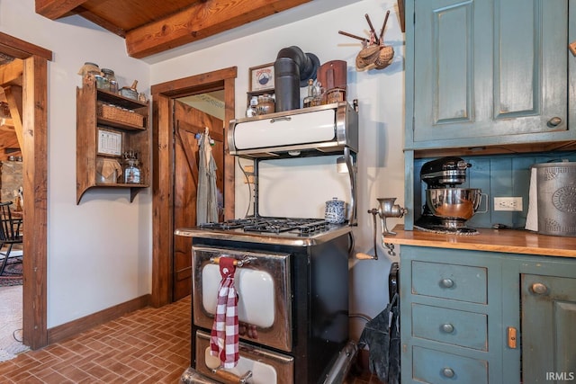 kitchen with baseboards, blue cabinets, brick floor, light countertops, and open shelves