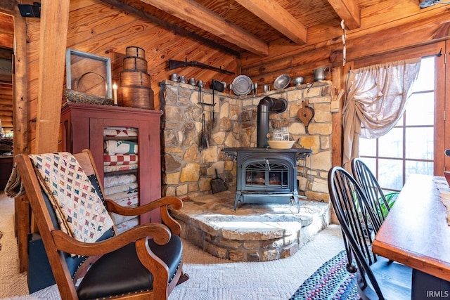 interior space featuring a wealth of natural light, a wood stove, wooden ceiling, and beamed ceiling