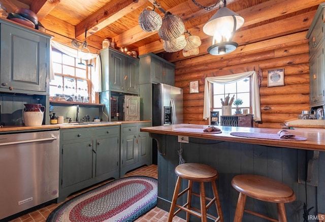 kitchen with wood ceiling, stainless steel appliances, a breakfast bar area, and beam ceiling