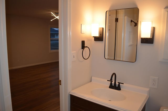 bathroom featuring wood finished floors, vanity, and baseboards