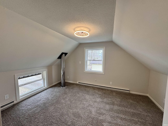 additional living space with a baseboard heating unit, carpet floors, a textured ceiling, and lofted ceiling