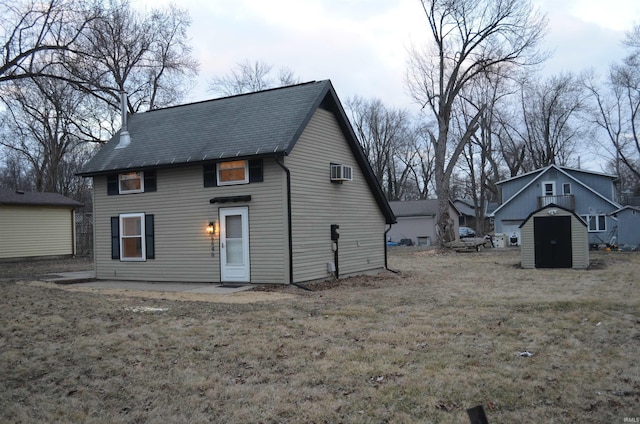 rear view of house featuring a shed, a wall mounted air conditioner, a patio, and an outbuilding