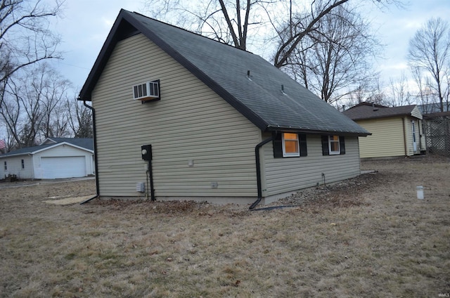 view of property exterior featuring a garage, an outdoor structure, and a wall mounted air conditioner