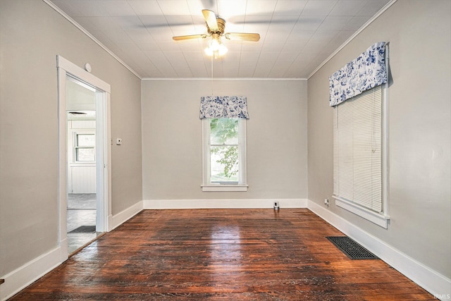 spare room with baseboards, visible vents, ceiling fan, wood finished floors, and crown molding