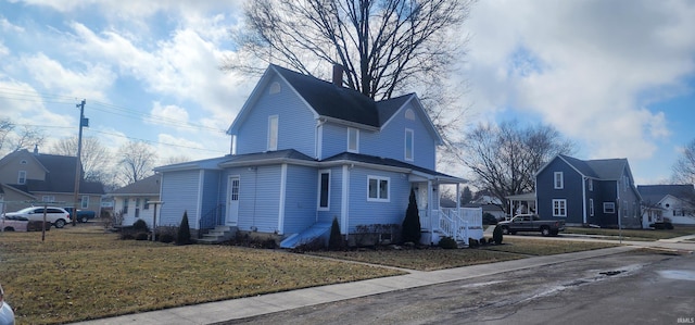 view of side of property featuring entry steps, a yard, and a residential view