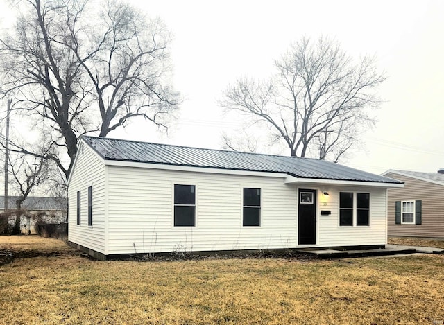 view of front of house with metal roof and a front lawn