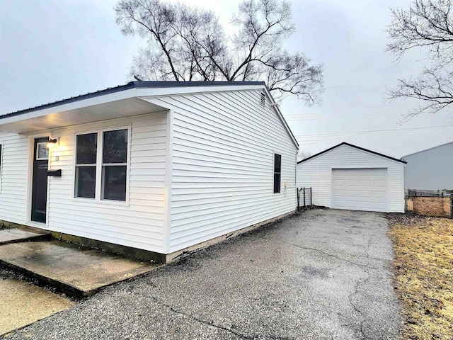 view of home's exterior with a garage, driveway, and an outdoor structure