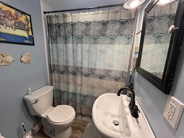 full bathroom with a shower with shower curtain, a sink, and toilet