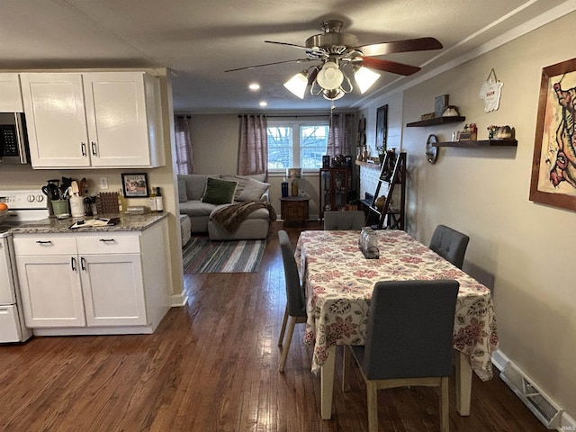 dining room featuring dark wood-style floors, crown molding, visible vents, ceiling fan, and baseboards