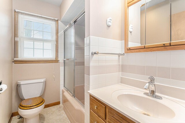 full bath with enclosed tub / shower combo, toilet, vanity, baseboards, and decorative backsplash